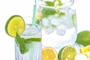glass and pitcher of mineral water with lemon and mint